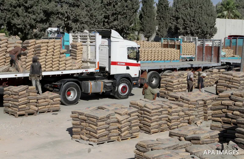 Palestinian workers offload a truck loaded with cement after it entered from Egypt through the Rafah border crossing in southern Gaza Strip, on June 13, 2015. Egyptian authorities for the first time since the expulsion o...