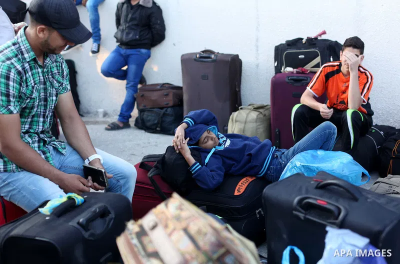Palestinians gather at the Rafah border crossing in the southern Gaza Strip, as they await permission to enter Egypt on June 14, 2015. Egypt is due to reopen its Rafah border crossing with Gaza for three days. The Rafah...