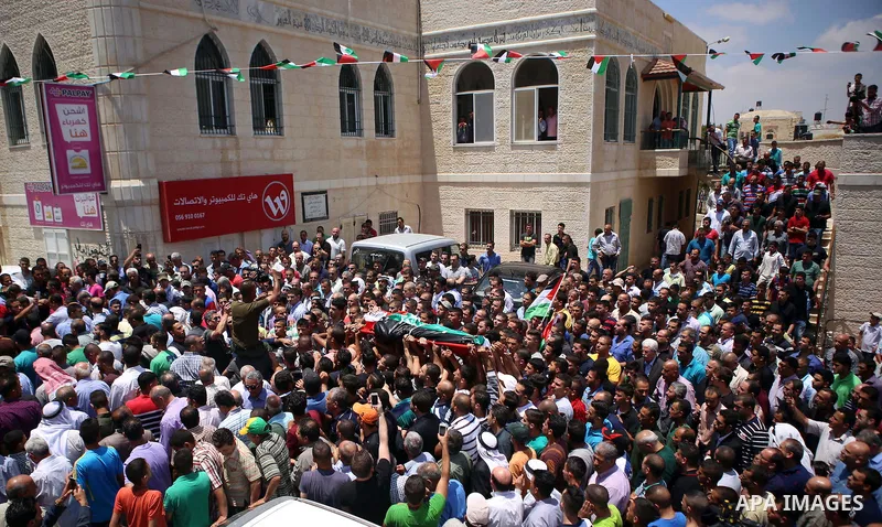 Mourners carry the body of 21-year-old Palestinian Abdallah Ghanayem, during his funeral in the village of Kafr Malik, northeast of Ramallah on June 14, 2015. An army spokesman said that the Palestinian had died after he...