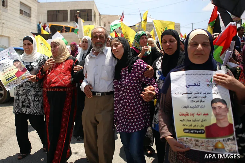 Relatives of 21-year-old Palestinian Abdallah Ghanayem, mourn during his funeral in the village of Kafr Malik, northeast of Ramallah on June 14, 2015. An army spokesman said that the Palestinian had died after he threw a...