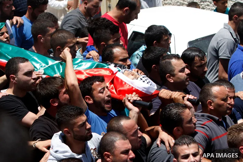 Mourners carry the body of 21-year-old Palestinian Abdallah Ghanayem, during his funeral in the village of Kafr Malik, northeast of Ramallah on June 14, 2015. An army spokesman said that the Palestinian had died after he...