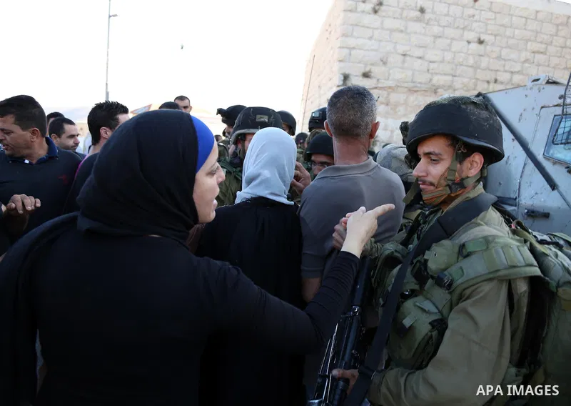 A Palestinian woman argues with Israeli soldiers in the village of Kafr Malik, northeast of Ramallah on June 14, 2015, after clashes that resulted in the death of 21-year-old Palestinian Abdallah Ghanayem. An army spokes...
