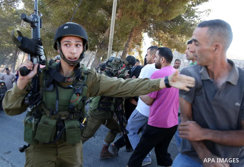 An Israeli soldier gestures during confrontations with Palestinians in the village of Kafr Malik, northeast of Ramallah on June 14, 2015, after clashes that resulted in the death of 21-year-old Palestinian Abdallah Ghana...