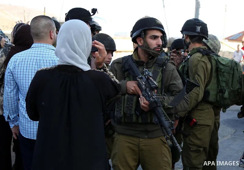 Palestinians argue with Israeli soldiers in the village of Kafr Malik, northeast of Ramallah on June 14, 2015, after clashes that resulted in the death of 21-year-old Palestinian Abdallah Ghanayem. An army spokesman said...