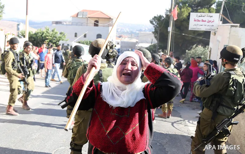 A Palestinian woman reacts during confrontations between Palestinians and Israeli soldiers in the village of Kafr Malik, northeast of Ramallah on June 14, 2015, after clashes that resulted in the death of 21-year-old Pal...
