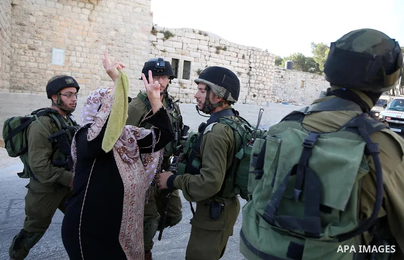 A Palestinian woman argues with Israeli soldiers in the village of Kafr Malik, northeast of Ramallah on June 14, 2015, after clashes that resulted in the death of 21-year-old Palestinian Abdallah Ghanayem. An army spokes...