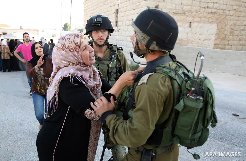 A Palestinian woman argues with Israeli soldiers in the village of Kafr Malik, northeast of Ramallah on June 14, 2015, after clashes that resulted in the death of 21-year-old Palestinian Abdallah Ghanayem. An army spokes...