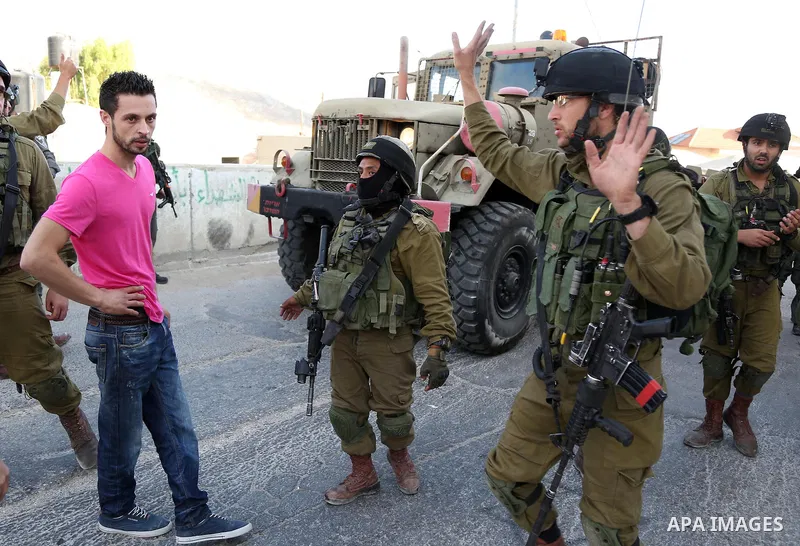 An Israeli soldier gestures during confrontations with Palestinians in the village of Kafr Malik, northeast of Ramallah on June 14, 2015, after clashes that resulted in the death of 21-year-old Palestinian Abdallah Ghana...