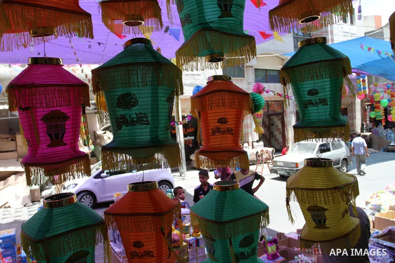 Palestinians walk at a market decorated by traditional Ramadan lanterns known as "Fanous" at a market, ahead of the holy fasting month of Ramadan in Khan Younis in the southern Gaza Strip, June 14, 2015. Photo by Abed Ra...