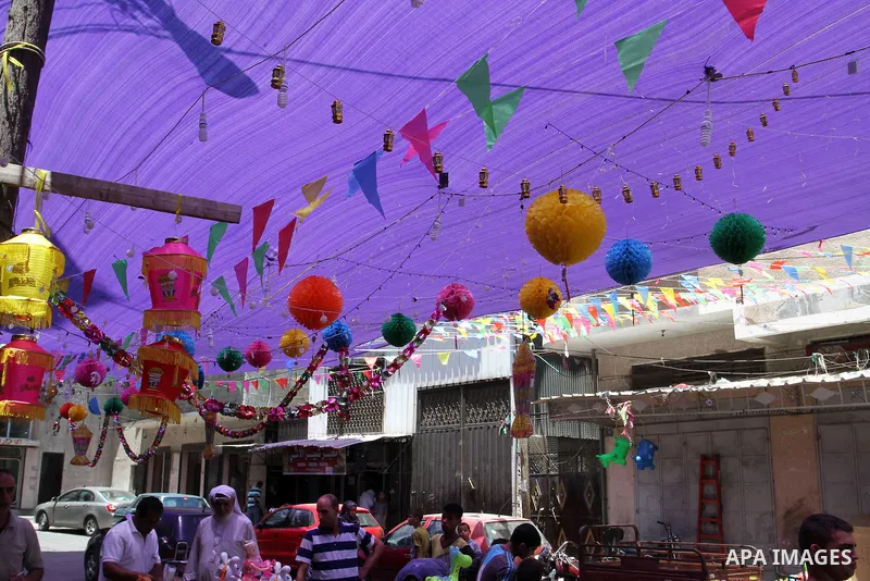 Palestinians walk at a market decorated by traditional Ramadan lanterns known as "Fanous" at a market, ahead of the holy fasting month of Ramadan in Khan Younis in the southern Gaza Strip, June 14, 2015. Photo by Abed Ra...
