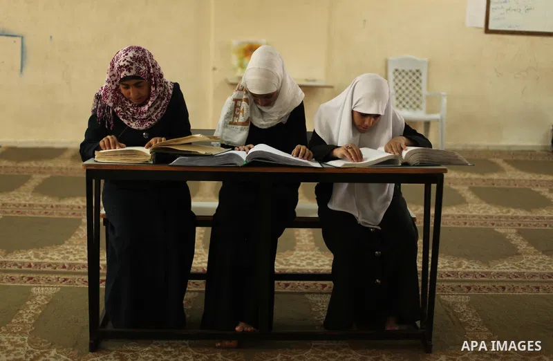 Palestinian girls read verses from the Quran during a class on how to read Islam's holy book, at Dar Al Ketab and sunna in Gaza city, on June 15, 2015. A summer camp in the Gaza Strip, Dar Al Ketab and sunna, plans to te...