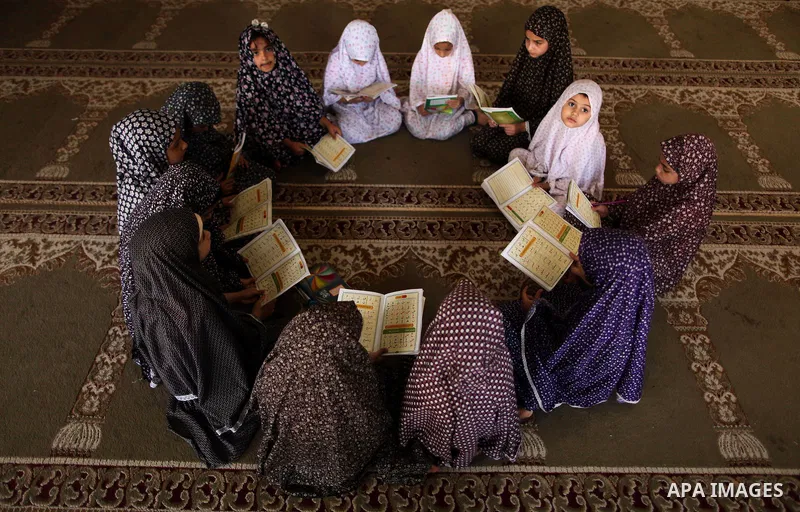 Palestinian girls read verses from the Quran during a class on how to read Islam's holy book, at Dar Al Ketab and sunna in Gaza city, on June 15, 2015. A summer camp in the Gaza Strip, Dar Al Ketab and sunna, plans to te...