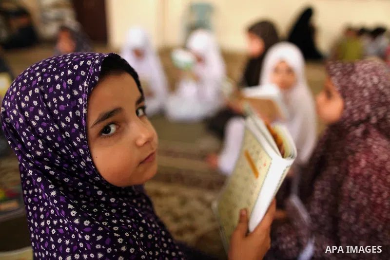 Palestinian girls read verses from the Quran during a class on how to read Islam's holy book, at Dar Al Ketab and sunna in Gaza city, on June 15, 2015. A summer camp in the Gaza Strip, Dar Al Ketab and sunna, plans to te...