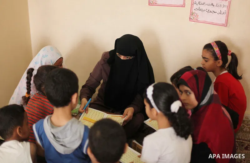 Palestinian girls read verses from the Quran during a class on how to read Islam's holy book, at Dar Al Ketab and sunna in Gaza city, on June 15, 2015. A summer camp in the Gaza Strip, Dar Al Ketab and sunna, plans to te...