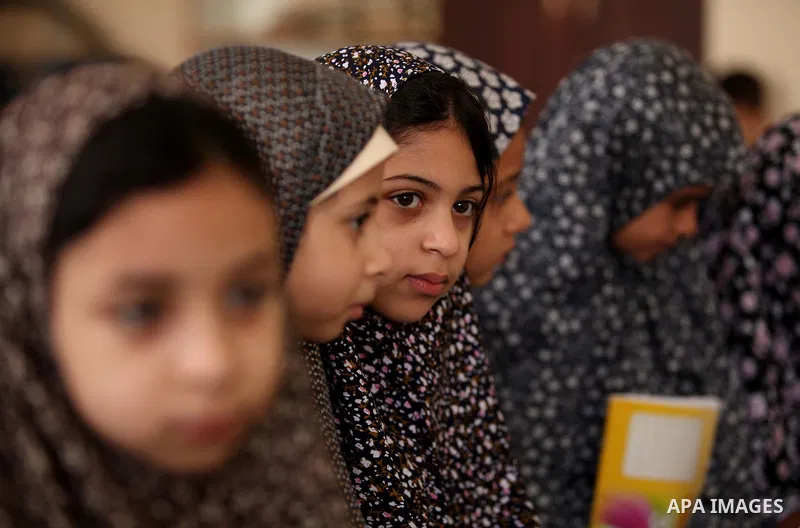 Palestinian girls read verses from the Quran during a class on how to read Islam's holy book, at Dar Al Ketab and sunna in Gaza city, on June 15, 2015. A summer camp in the Gaza Strip, Dar Al Ketab and sunna, plans to te...
