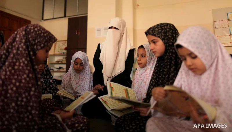 Palestinian girls read verses from the Quran during a class on how to read Islam's holy book, at Dar Al Ketab and sunna in Gaza city, on June 15, 2015. A summer camp in the Gaza Strip, Dar Al Ketab and sunna, plans to te...