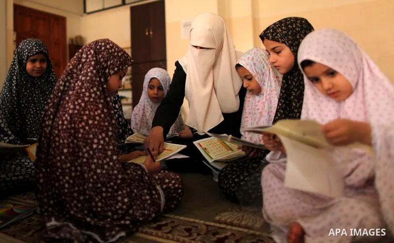 Palestinian girls read verses from the Quran during a class on how to read Islam's holy book, at Dar Al Ketab and sunna in Gaza city, on June 15, 2015. A summer camp in the Gaza Strip, Dar Al Ketab and sunna, plans to te...
