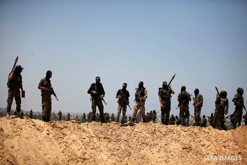 Palestinian militants of Al-Nasser Brigades, the armed wing of the Popular Resistance Committees, hold up their weapons during a military march, in Beit Hanoun in the northern Gaza Strip, June 16, 2015. Photo by Ashraf A...