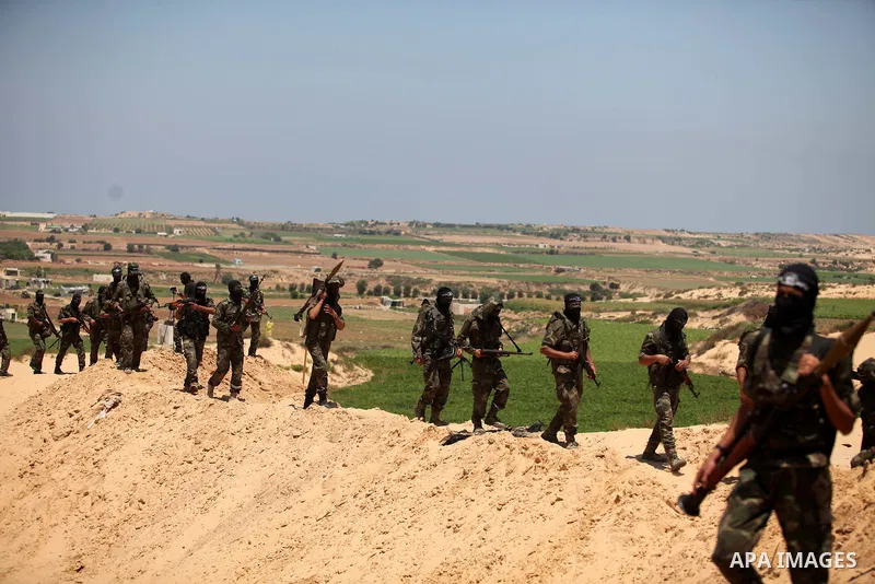 Palestinian militants of Al-Nasser Brigades, the armed wing of the Popular Resistance Committees, hold up their weapons during a military march, in Beit Hanoun in the northern Gaza Strip, June 16, 2015. Photo by Ashraf A...