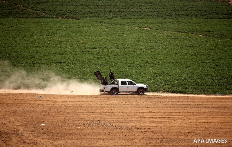 Palestinian militants of Al-Nasser Brigades, the armed wing of the Popular Resistance Committees, ride a car during a military march, in Beit Hanoun in the northern Gaza Strip, June 16, 2015. Photo by Ashraf Amra