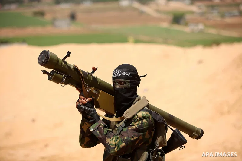 Palestinian militants of Al-Nasser Brigades, the armed wing of the Popular Resistance Committees, hold up their weapons during a military march, in Beit Hanoun in the northern Gaza Strip, June 16, 2015. Photo by Ashraf A...