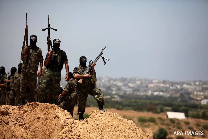 Palestinian militants of Al-Nasser Brigades, the armed wing of the Popular Resistance Committees, hold up their weapons during a military march, in Beit Hanoun in the northern Gaza Strip, June 16, 2015. Photo by Ashraf A...