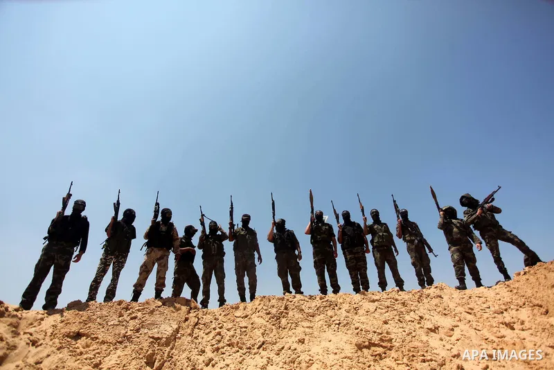 Palestinian militants of Al-Nasser Brigades, the armed wing of the Popular Resistance Committees, hold up their weapons during a military march, in Beit Hanoun in the northern Gaza Strip, June 16, 2015. Photo by Ashraf A...