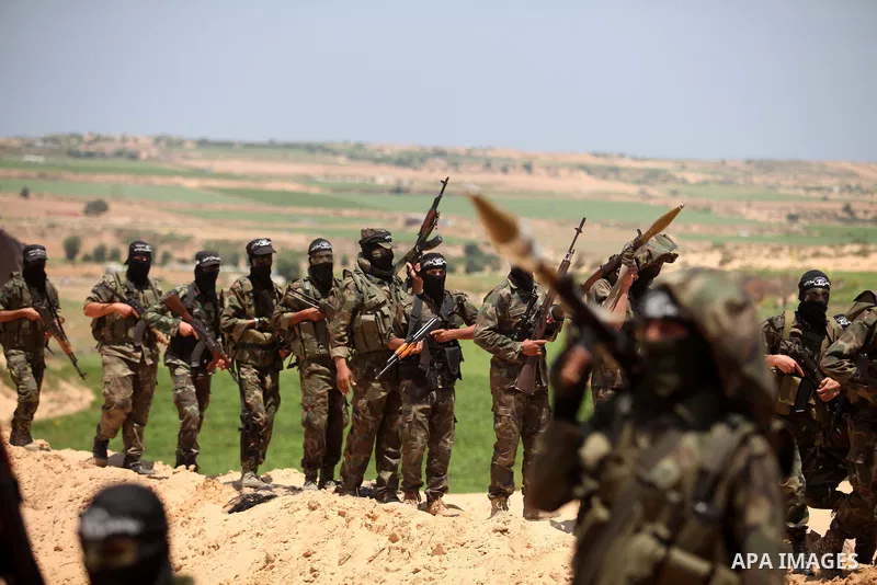 Palestinian militants of Al-Nasser Brigades, the armed wing of the Popular Resistance Committees, hold up their weapons during a military march, in Beit Hanoun in the northern Gaza Strip, June 16, 2015. Photo by Ashraf A...