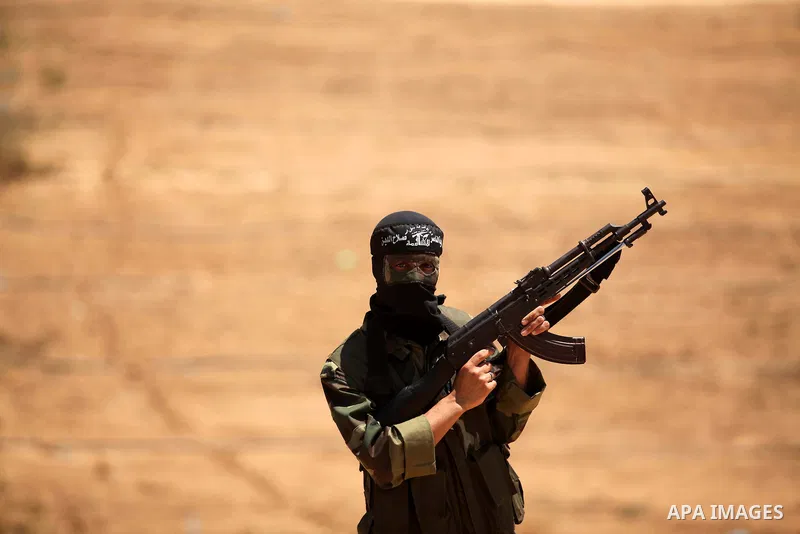 Palestinian militants of Al-Nasser Brigades, the armed wing of the Popular Resistance Committees, hold up their weapons during a military march, in Beit Hanoun in the northern Gaza Strip, June 16, 2015. Photo by Ashraf A...
