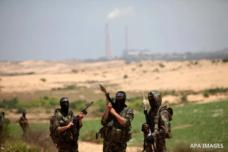 Palestinian militants of Al-Nasser Brigades, the armed wing of the Popular Resistance Committees, hold up their weapons during a military march, in Beit Hanoun in the northern Gaza Strip, June 16, 2015. Photo by Ashraf A...