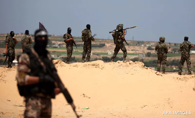 Palestinian militants of Al-Nasser Brigades, the armed wing of the Popular Resistance Committees, hold up their weapons during a military march, in Beit Hanoun in the northern Gaza Strip, June 16, 2015. Photo by Ashraf A...