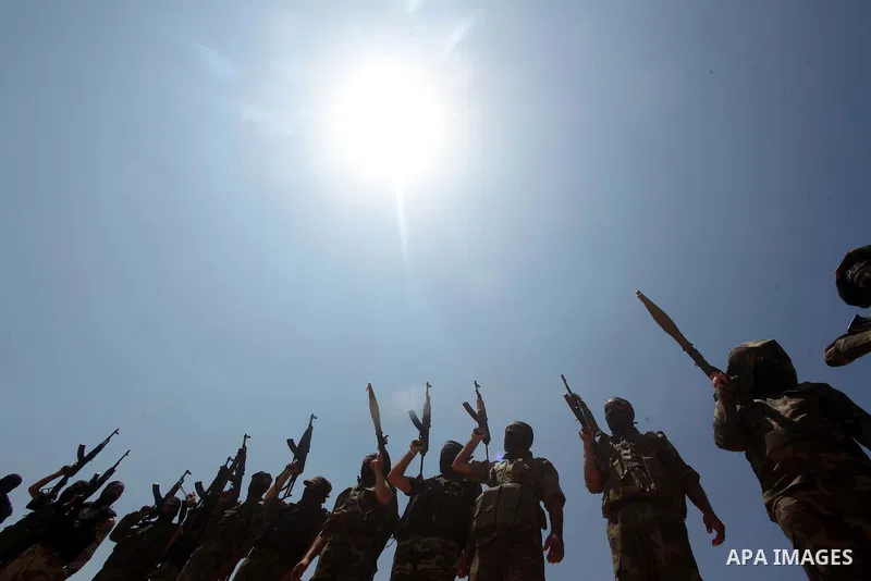 Palestinian militants of Al-Nasser Brigades, the armed wing of the Popular Resistance Committees, hold up their weapons during a military march, in Beit Hanoun in the northern Gaza Strip, June 16, 2015. Photo by Ashraf A...