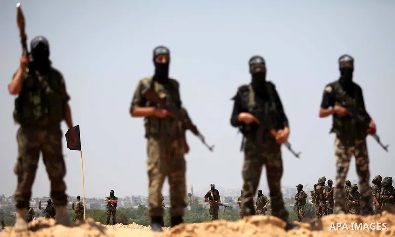 Palestinian militants of Al-Nasser Brigades, the armed wing of the Popular Resistance Committees, hold up their weapons during a military march, in Beit Hanoun in the northern Gaza Strip, June 16, 2015. Photo by Ashraf A...