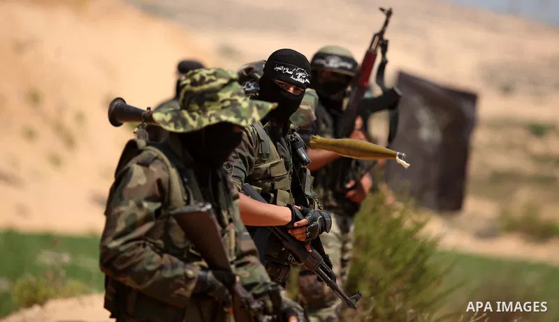 Palestinian militants of Al-Nasser Brigades, the armed wing of the Popular Resistance Committees, hold up their weapons during a military march, in Beit Hanoun in the northern Gaza Strip, June 16, 2015. Photo by Ashraf A...
