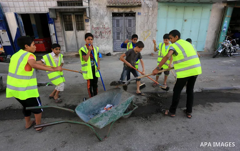 Palestinian youths participate in an event to clean roads ahead of the holy fasting month of Ramadan in Gaza city on, June 16, 2015. Photo by Mohammed Asad