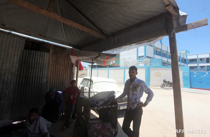 Palestinians sit in front a tent outside a UN-run school in Gaza City on June 18, 2015. "UNRWA" announced that they are closed the last affiliate accommodation centers in the Gaza Strip after paid to the displaced Palest...