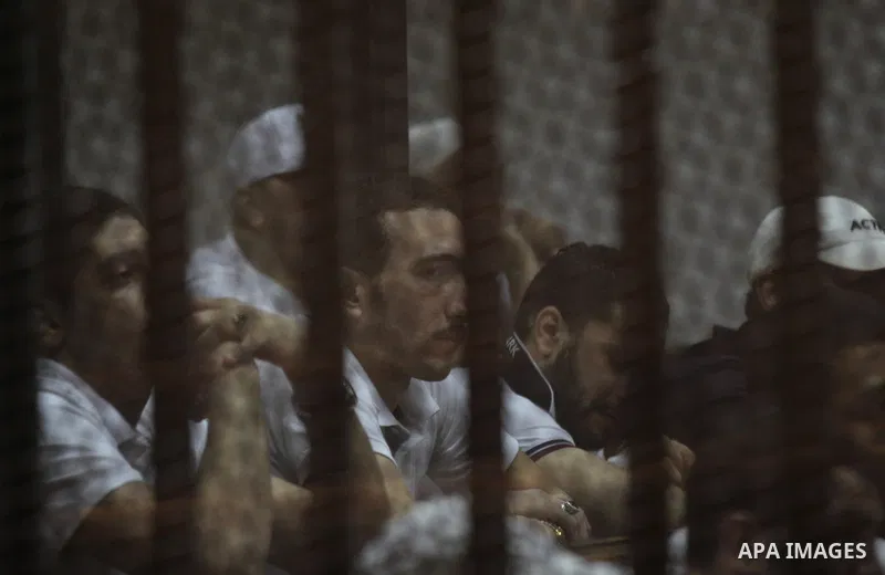 Egyptian defendants react behind bars after the verdict in their retrial over a 2012 stadium riot in the canal city of Port Said that left 74 people dead, in a court in the Egyptian capital, Cairo on June 20, 2015. Photo...