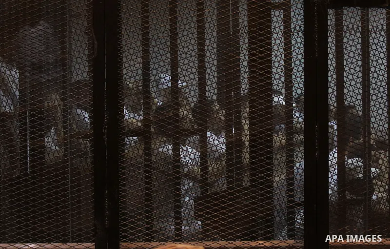 Egyptian defendants react behind bars after the verdict in their retrial over a 2012 stadium riot in the canal city of Port Said that left 74 people dead, in a court in the Egyptian capital, Cairo on June 20, 2015. Photo...