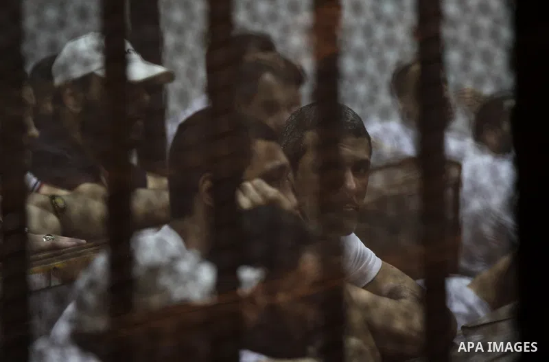 Egyptian defendants react behind bars after the verdict in their retrial over a 2012 stadium riot in the canal city of Port Said that left 74 people dead, in a court in the Egyptian capital, Cairo on June 20, 2015. Photo...