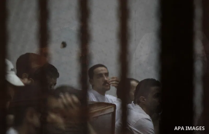 Egyptian defendants react behind bars after the verdict in their retrial over a 2012 stadium riot in the canal city of Port Said that left 74 people dead, in a court in the Egyptian capital, Cairo on June 20, 2015. Photo...
