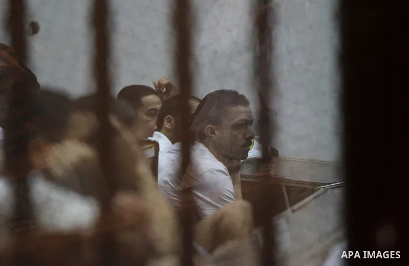 Egyptian defendants react behind bars after the verdict in their retrial over a 2012 stadium riot in the canal city of Port Said that left 74 people dead, in a court in the Egyptian capital, Cairo on June 20, 2015. Photo...