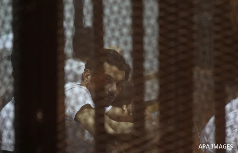Egyptian defendants react behind bars after the verdict in their retrial over a 2012 stadium riot in the canal city of Port Said that left 74 people dead, in a court in the Egyptian capital, Cairo on June 20, 2015. Photo...