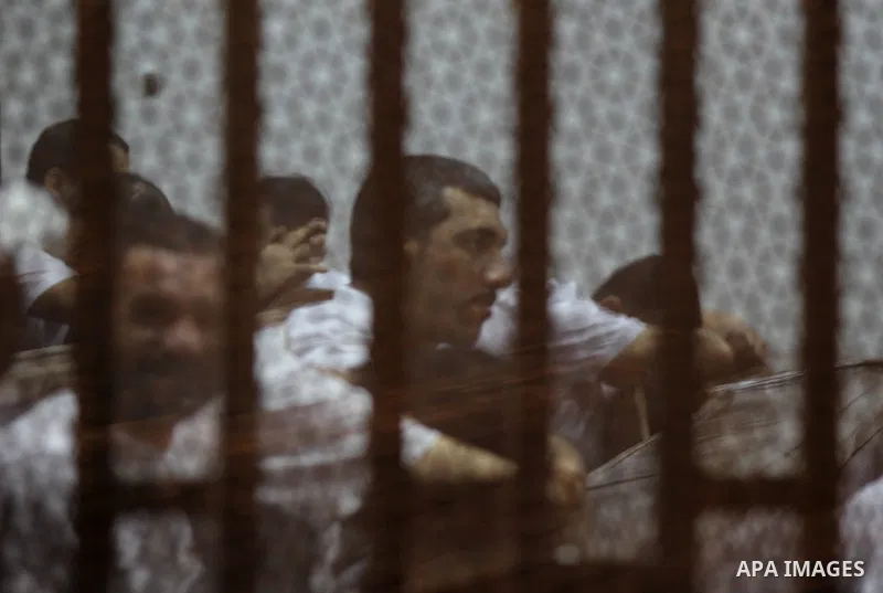 Egyptian defendants react behind bars after the verdict in their retrial over a 2012 stadium riot in the canal city of Port Said that left 74 people dead, in a court in the Egyptian capital, Cairo on June 20, 2015. Photo...