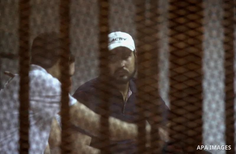 Egyptian defendants react behind bars after the verdict in their retrial over a 2012 stadium riot in the canal city of Port Said that left 74 people dead, in a court in the Egyptian capital, Cairo on June 20, 2015. Photo...