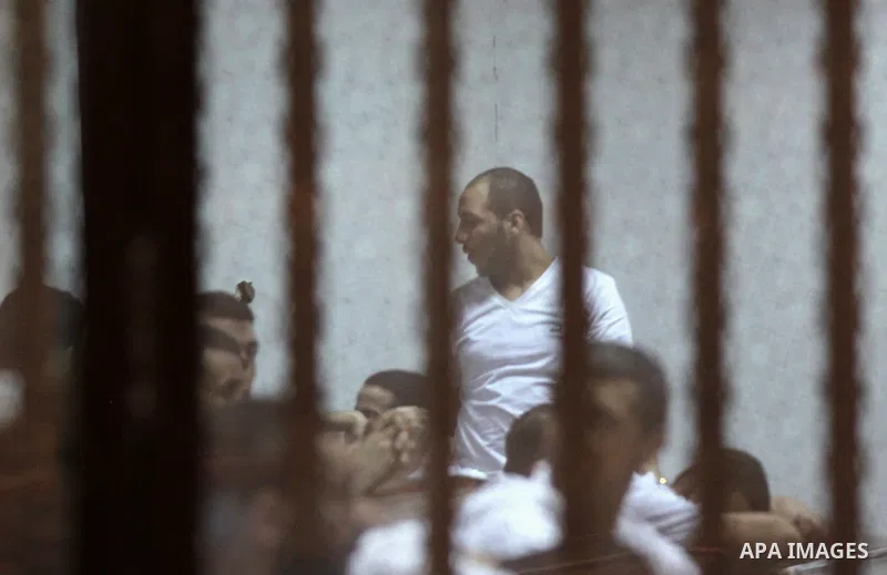 Egyptian defendants react behind bars after the verdict in their retrial over a 2012 stadium riot in the canal city of Port Said that left 74 people dead, in a court in the Egyptian capital, Cairo on June 20, 2015. Photo...