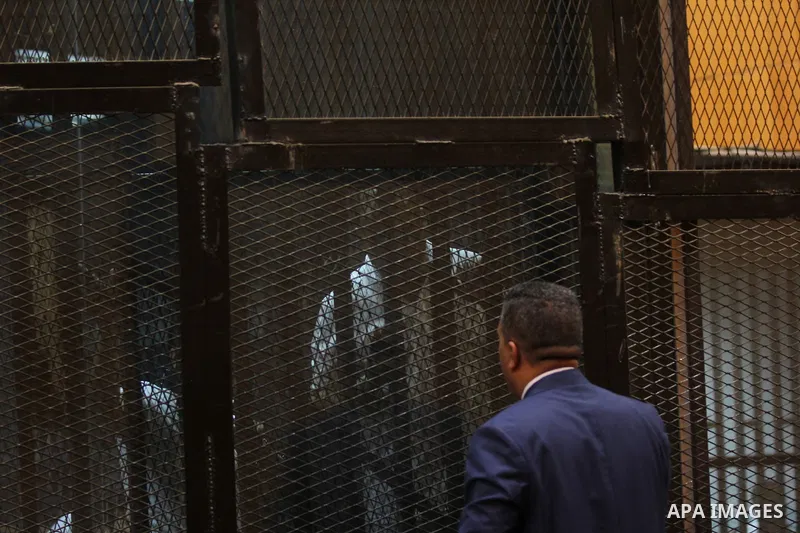 Egyptian defendants react behind bars after the verdict in their retrial over a 2012 stadium riot in the canal city of Port Said that left 74 people dead, in a court in the Egyptian capital, Cairo on June 20, 2015. Photo...