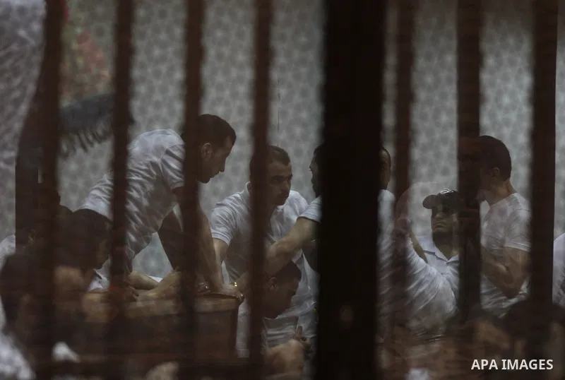 Egyptian defendants react behind bars after the verdict in their retrial over a 2012 stadium riot in the canal city of Port Said that left 74 people dead, in a court in the Egyptian capital, Cairo on June 20, 2015. Photo...