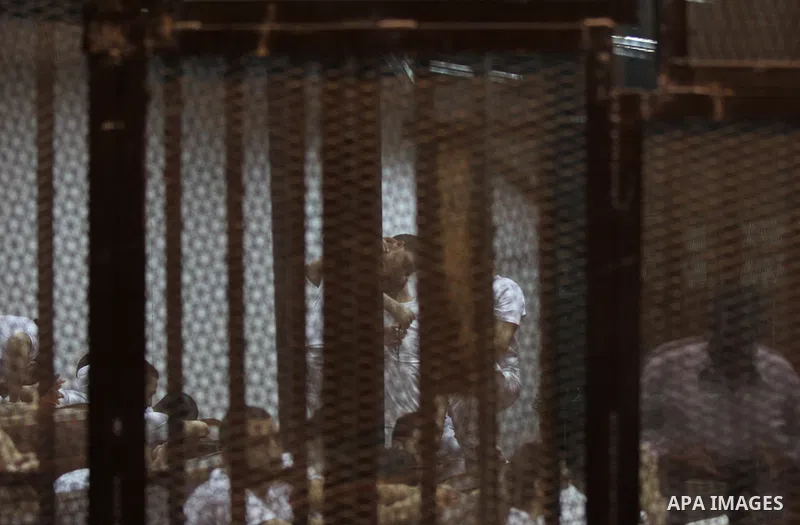 Egyptian defendants react behind bars after the verdict in their retrial over a 2012 stadium riot in the canal city of Port Said that left 74 people dead, in a court in the Egyptian capital, Cairo on June 20, 2015. Photo...