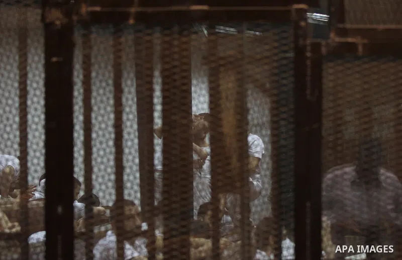 Egyptian defendants react behind bars after the verdict in their retrial over a 2012 stadium riot in the canal city of Port Said that left 74 people dead, in a court in the Egyptian capital, Cairo on June 20, 2015. Photo...