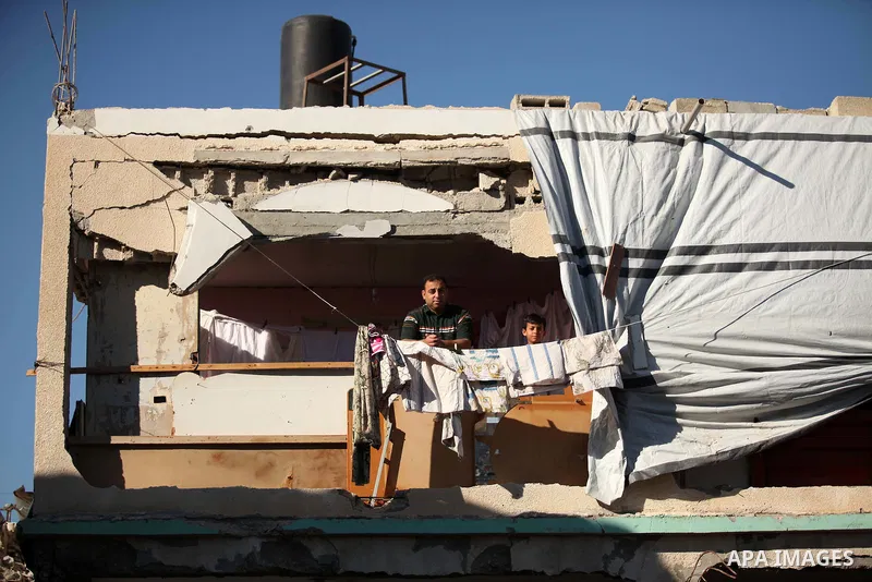 Palestinians stand on the remains of a building that was destroyed during 50-day Israeli on Gaza Strip in the summer of 2014, east of Khan Younis in the southern Gaza Strip on June 22, 2015. A widely anticipated United N...